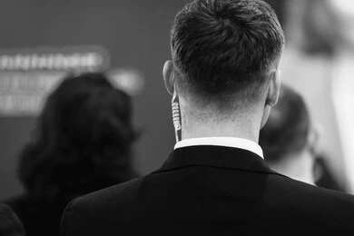 2700652745 Security personnel with earpiece at event