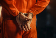 Cold Case Confrontation Turns Intense Individual in an orange jumpsuit with hands cuffed behind their back