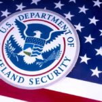 DHS Warns States: Comply Or Face Penalties U.S. Department of Homeland Security seal on American flag