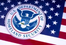 DHS Warns States: Comply Or Face Penalties U.S. Department of Homeland Security seal on American flag