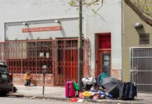 NYC U-Turn: Camps Cleared In 7 Days Sidewalk scene outside a housing clinic with people and belongings