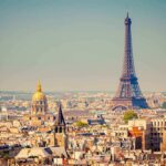What France’s Heatwave Really Cost A panoramic view of Paris featuring the Eiffel Tower and a golden dome