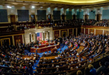 Bipartisan Win, No Signature—What Just Happened? A large gathering of officials in a congressional chamber during a legislative session
