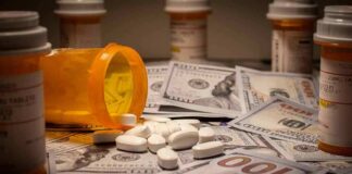 Prescription pill bottle and white tablets on scattered US dollar bills