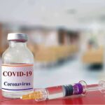 Pandemic Secrets Return To The Spotlight vaccine vial and syringe on a counter in a clinic