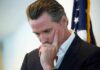 Is Newsom Right About Capitalism’s Failures? man in suit touching his face thoughtfully