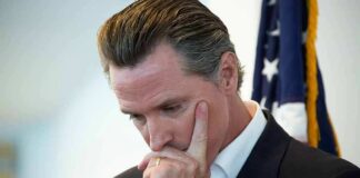 man in suit touching his face thoughtfully