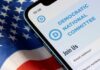 Former Mayor Breaks With Democrats Mobile phone displaying Democratic National Committee website on an American flag background