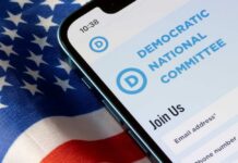 Mobile phone displaying Democratic National Committee website on an American flag background