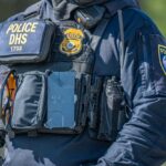 Family Seeks Answers After ICE Shooting Police officer in tactical vest with equipment and radio