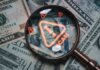 Investigators Trace Scams To U.S. Tech Magnifying glass over U.S. dollar bills with a scam warning