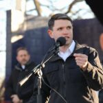 Why Critics Are Targeting Talarico Individual speaking into a microphone at an outdoor event