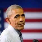 Obama’s Election Comments Face New Scrutiny man speaking at podium with american flag backdrop