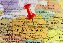 Red pushpin marking Poland on a European map