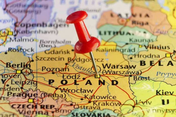 Red pushpin marking Poland on a European map