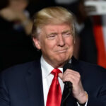 Rushmore Speech Warns America Under Attack Donald Trump speaking at a rally with a microphone