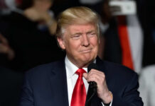 Rushmore Speech Warns America Under Attack Donald Trump speaking at a rally with a microphone