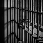 Close-up of prison bars casting shadows on a wall
