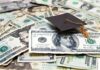 Graduation cap on a pile of US dollar bills
