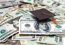 Graduation cap on a pile of US dollar bills