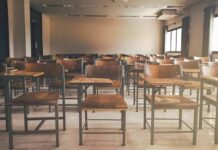 Empty classroom with rows of wooden desks and chairs