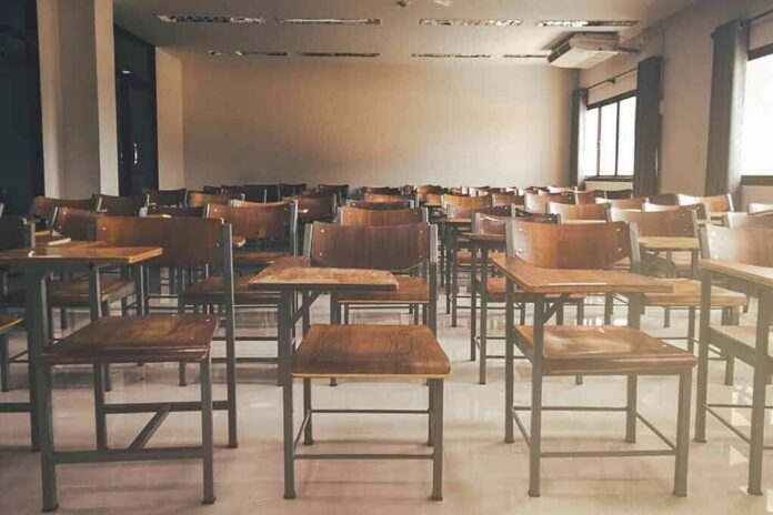 shutterstock_1019829787 Empty classroom with rows of wooden desks and chairs