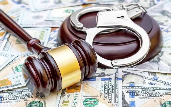 shutterstock_1074483872 Judge's gavel and handcuffs on pile of US dollar bills