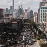 City street with heavy traffic and elevated subway tracks