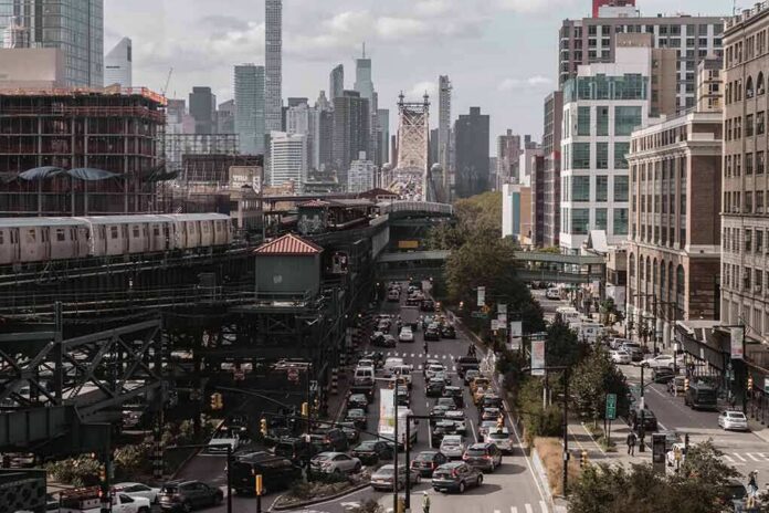 City street with heavy traffic and elevated subway tracks