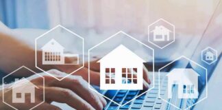 Hands typing on laptop with real estate house icons overlay