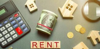 Rent payment concept with calculator, cash roll, coins, keys, and wooden house icons