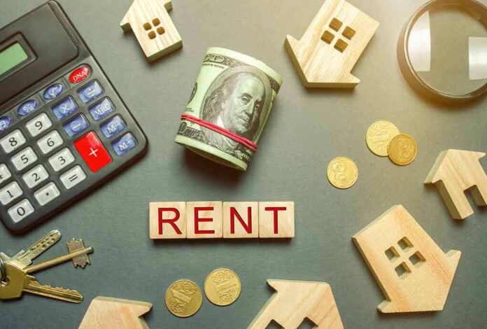 Rent payment concept with calculator, cash roll, coins, keys, and wooden house icons