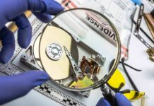 Forensics Undercut Narratives In Hunter Saga Forensic technician examining an open hard drive with a magnifying glass