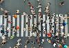Researchers Urge World Population Decline Crowd of pedestrians crossing a zebra crosswalk from above