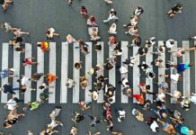 Crowd of pedestrians crossing a zebra crosswalk from above