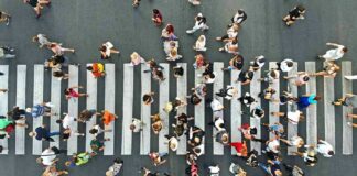 Crowd of pedestrians crossing a zebra crosswalk from above
