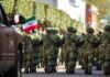 Bloodbath Erupts After Kingpin Takedown Soldiers in green camouflage march carrying rifles and a Mexican flag