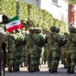 Bloodbath Erupts After Kingpin Takedown Soldiers in green camouflage march carrying rifles and a Mexican flag