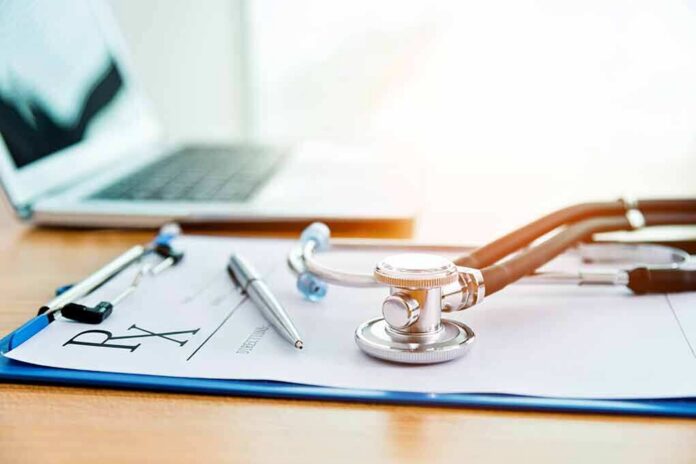 shutterstock_1605490033 Stethoscope on a prescription form beside a pen and laptop