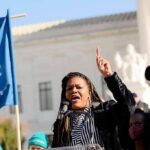 Dem Civil War Explodes In Missouri Woman speaking at a rally with raised finger and microphone