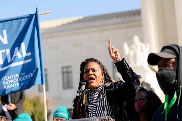 shutterstock_2105331638 Woman speaking at a rally with raised finger and microphone
