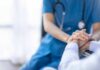 Nurse comforting a patient by holding hands