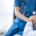Nurse comforting a patient by holding hands