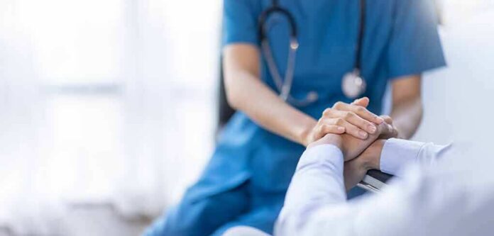 shutterstock_2219183715 Nurse comforting a patient by holding hands
