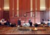 brass balance scale with files and gavel in a courtroom