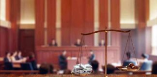 brass balance scale with files and gavel in a courtroom
