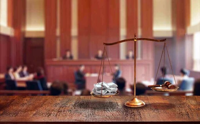 brass balance scale with files and gavel in a courtroom
