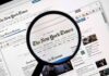 Jury Hammers NYT Over Botched Crime Story Magnifying glass over a newspaper website on a computer screen