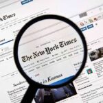 Jury Hammers NYT Over Botched Crime Story Magnifying glass over a newspaper website on a computer screen