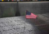 American flag on a rainy memorial nameplate.